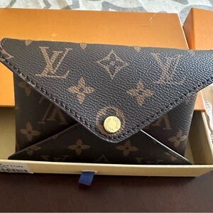 New medium size folding pouch in monogram style with red interior.